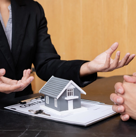 A real estate agent with a House model is talking to clients about buying home insurance home insurance concept dundalk md